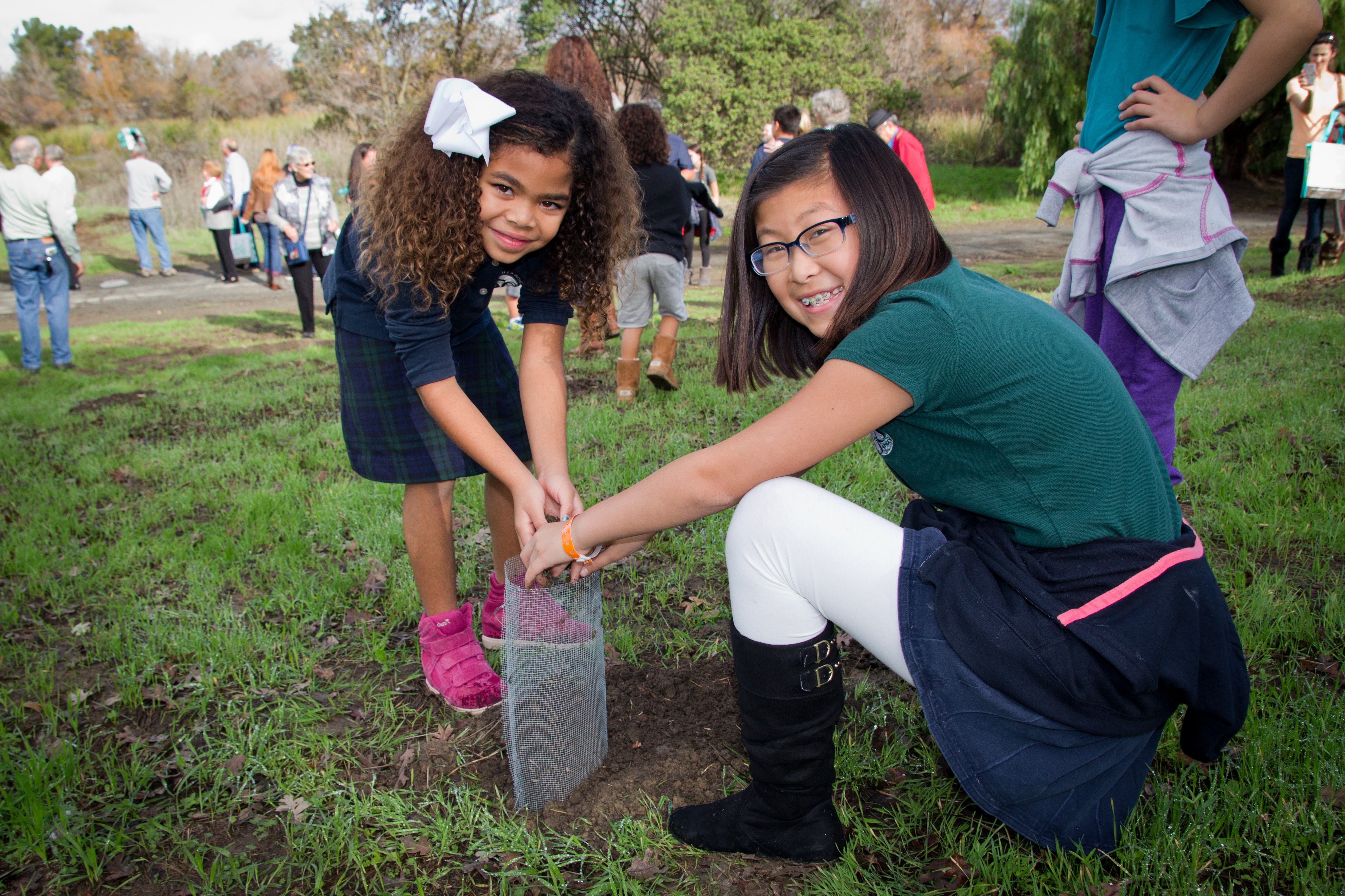 Two young girls planting a tree